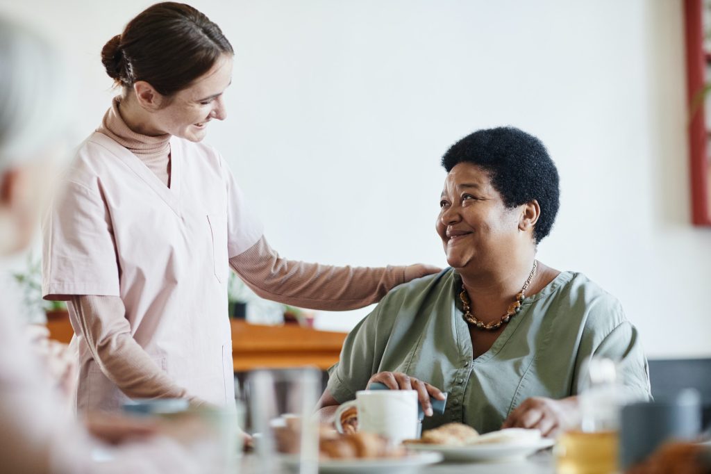 caring young woman working in nursing home